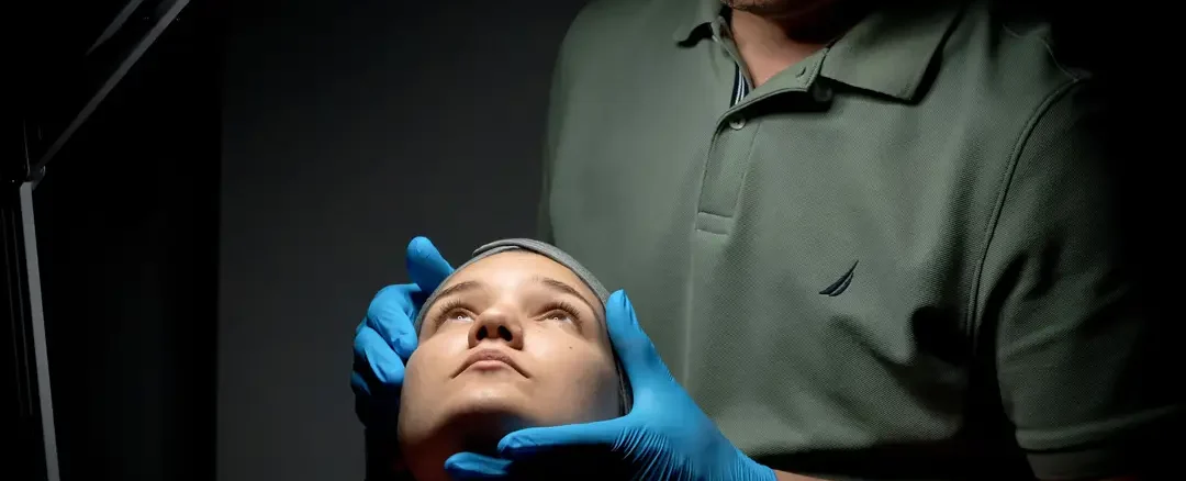 Especialista realizando evaluación facial previa a tratamiento de armonización facial en clínica